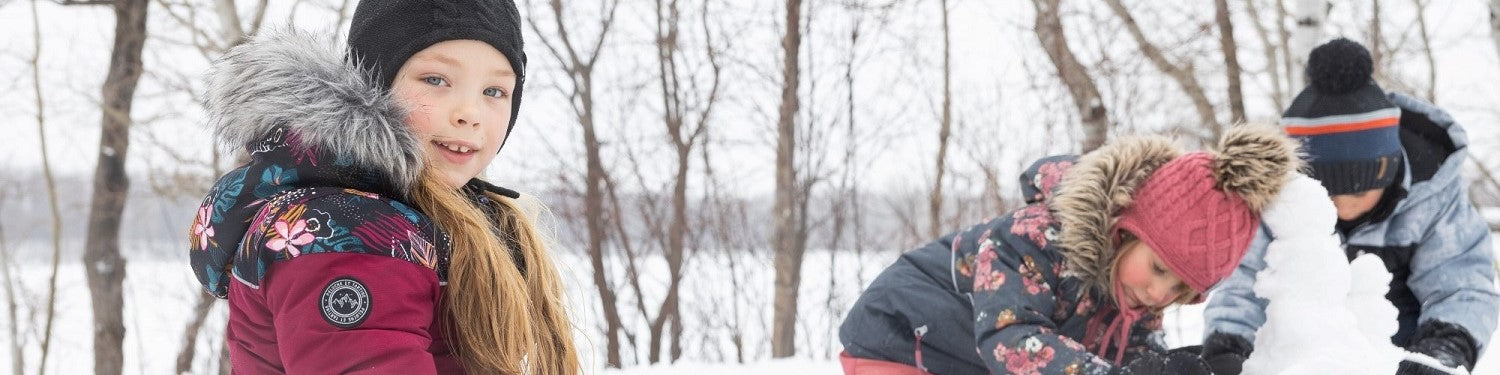 un groupe d'enfant fille souriante dans une fôret durant l'hiver